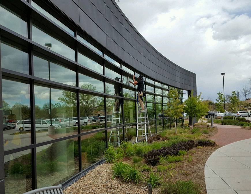 Commercial Building with a Praise windows employee cleaning the windows