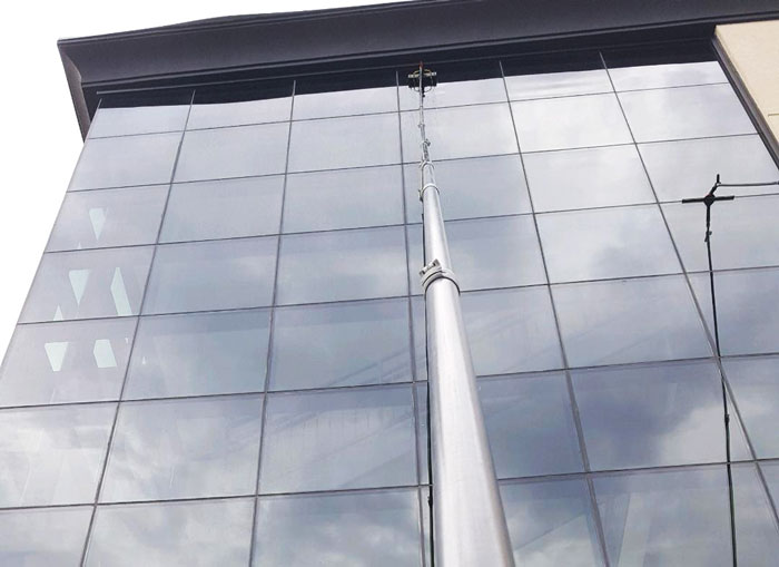 Cleaning commercial building windows with long pole